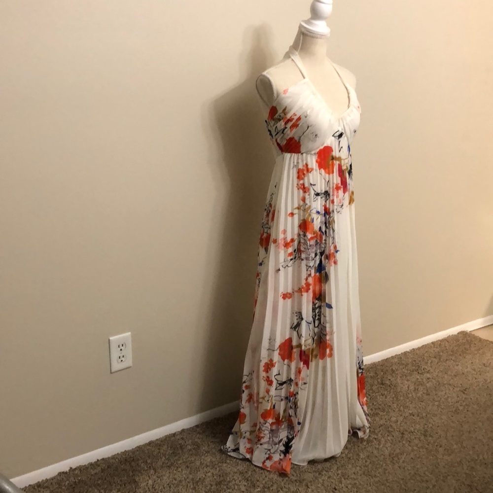 Halter tie-neck gown white with orange floral print. Elastic back. Flared pleats